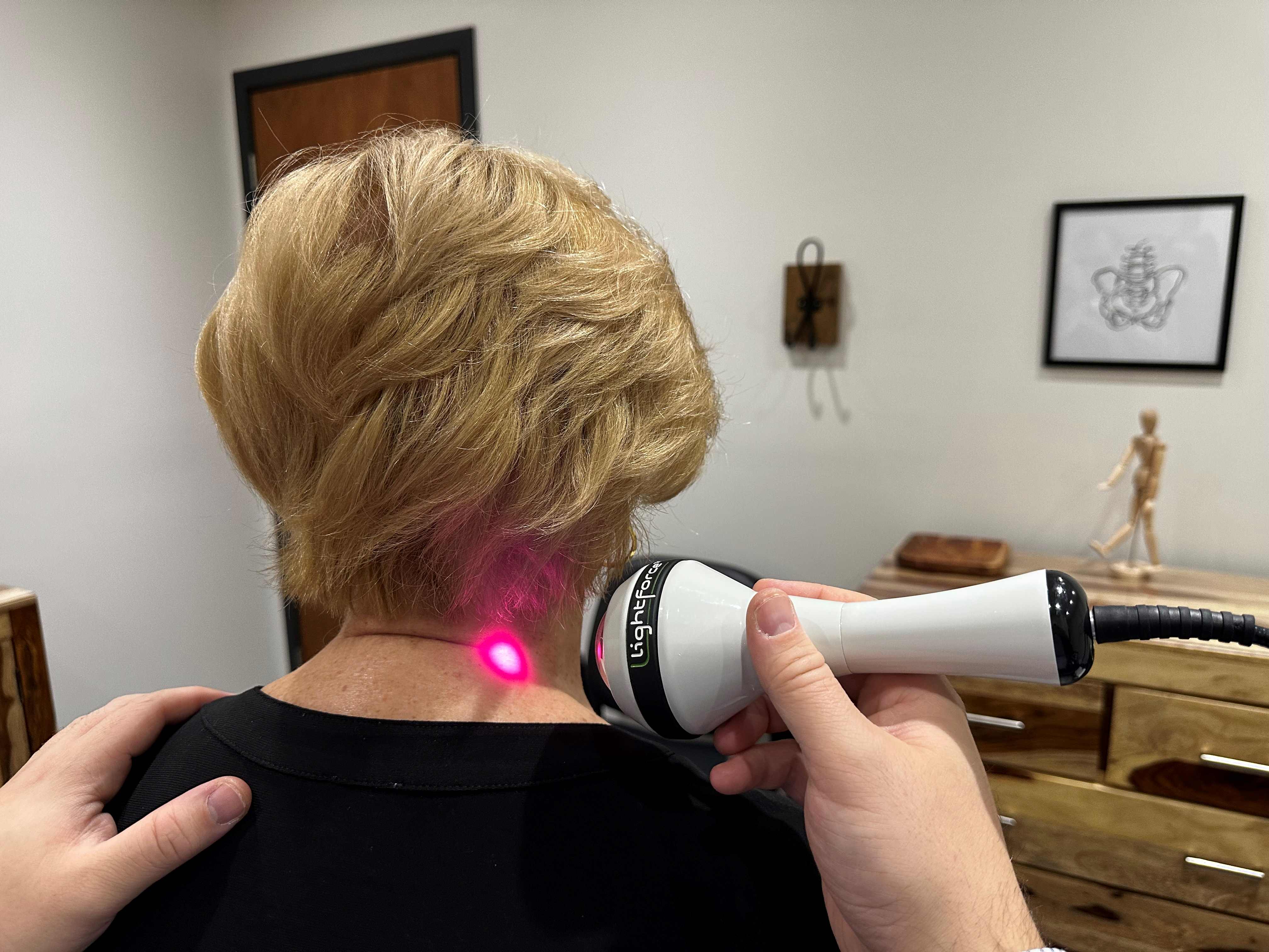 Application de laser sur le cou d'une patiente dans le cadre d'un traitement dans une clinique médicale