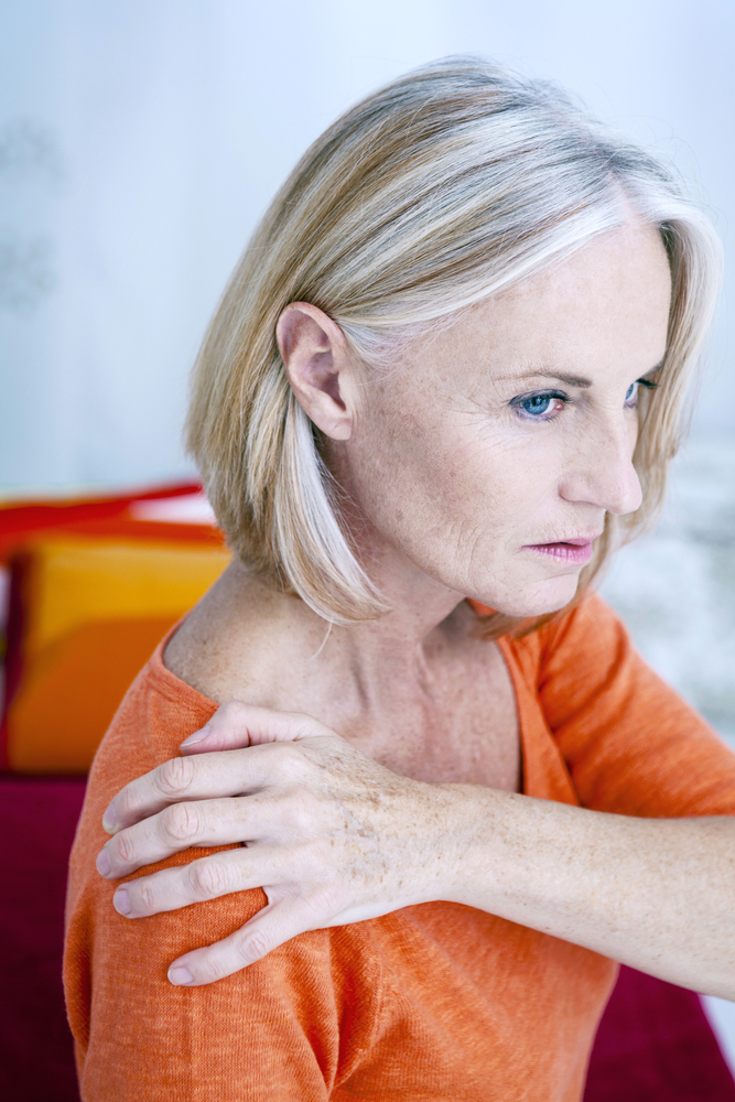 Femme qui se tient l'épaule qui semble douloureuse